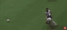 two soccer players are laying on the field and one has the number 23 on his shirt .