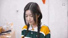a girl with braids wearing a green and yellow striped shirt with the number 01 on it