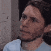 a man with a beard is making a funny face while sitting in front of a computer .