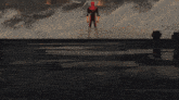 a man in a red suit is standing in front of a fire