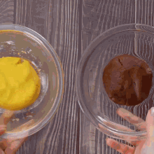 a person is holding a bowl of yellow dough and a bowl of brown dough