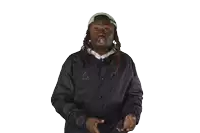 a man wearing a black jacket and a white hat wipes his face