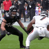 two football players are playing a game on a field and one has the number 7 on his jersey