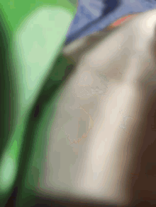 a blurred image of a person 's neck and shoulder