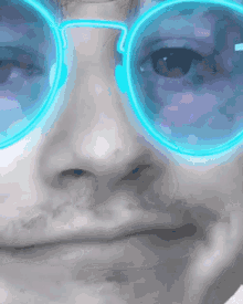 a close up of a person 's face with blue glasses