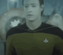 a close up of a man wearing a star trek uniform with a badge on his chest