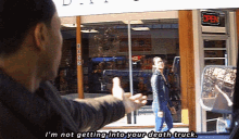 a man says i 'm not getting into your death truck while a woman walks in front of a store