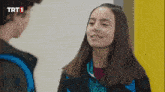 a boy and a girl are looking at each other with a trt1 logo in the corner