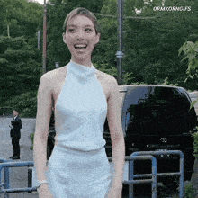 a woman in a white dress is standing in front of a black toyota van