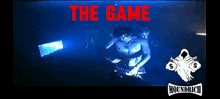 a man playing a dj set with the words " the game " written above him