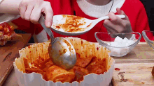 a person is dipping a spoon into a bowl of food that says weed on the cutting board