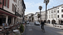 a man wearing a mask is riding a bicycle down a street