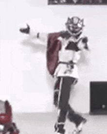 a person in a knight costume is standing in a room .
