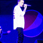 a man in a white shirt is singing into a microphone