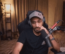 a man wearing headphones and a black shirt with the word adidas on it