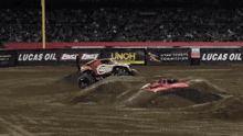 a monster truck is jumping in the air in front of a lucas oil banner