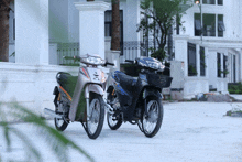 two motorcycles are parked in front of a building one of which has a basket on the front