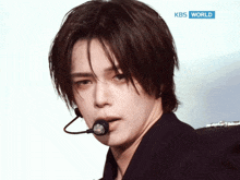 a close up of a man 's face with a kbs world logo in the background