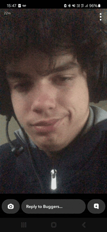 a phone screen shows a man wearing headphones and says reply to bugger