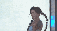 a woman with pigtails and a tattoo on her face is dancing in front of a large screen with the word halo on it ..