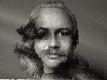 a black and white photo of a man with long hair and a beard