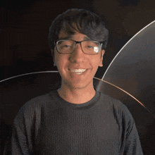 a man wearing glasses and a black ledger shirt