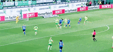 a soccer game is being played in front of banners for rinti
