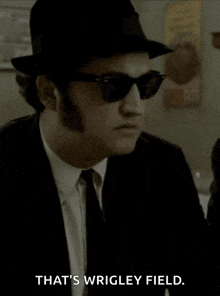 a man wearing a hat and sunglasses is saying that 's wrigley field