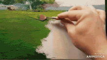 a person is painting a picture with a spoon and a brush