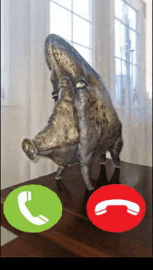 a statue of a pig talking on a phone with a green and red button