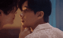 a man in a white shirt is touching another man 's neck