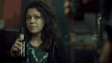 a woman wearing a black hoodie and a t-shirt that says ' a ' on it