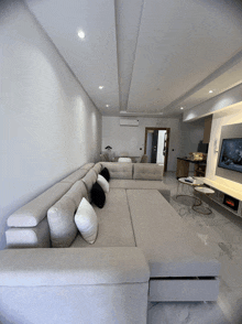 a living room with a large sectional couch and a tv