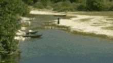 a river with a few boats in it and trees on the shore .