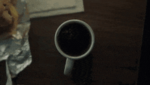 a cup of coffee with a bug in it on a table