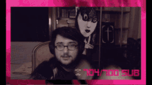a man wearing glasses and headphones is sitting in front of a pink background that says 104/100 sub
