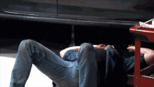 a man is laying on the ground working under a car