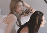 two women are laying on a bed and the caption says lingergifss