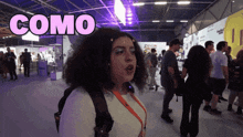 a woman stands in a crowd with the word como above her head