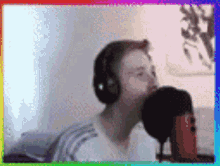 a blurry picture of a man wearing headphones and singing into a microphone