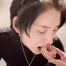 a close up of a person eating a donut with sugar on it