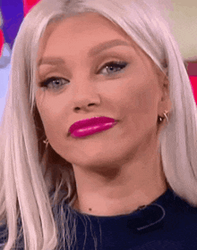 a close up of a woman 's face with bright pink lipstick