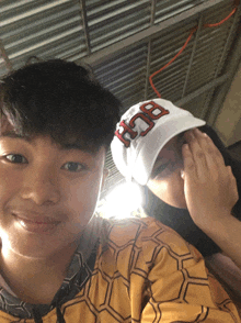a boy and a girl are posing for a picture and the boy is wearing a hat that says bch