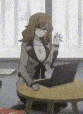 a woman sitting at a table with a laptop