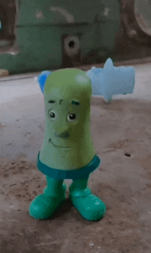 a green toy with a blue shirt and green boots