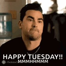 a man is making a face and says `` happy tuesday ! ''
