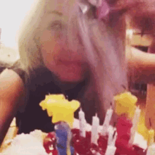 a woman blowing out candles on a cake