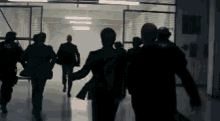 a group of people are running down a hallway in a dark room .