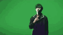 a man is standing in front of a green screen