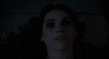 a close up of a woman 's face with a dark background